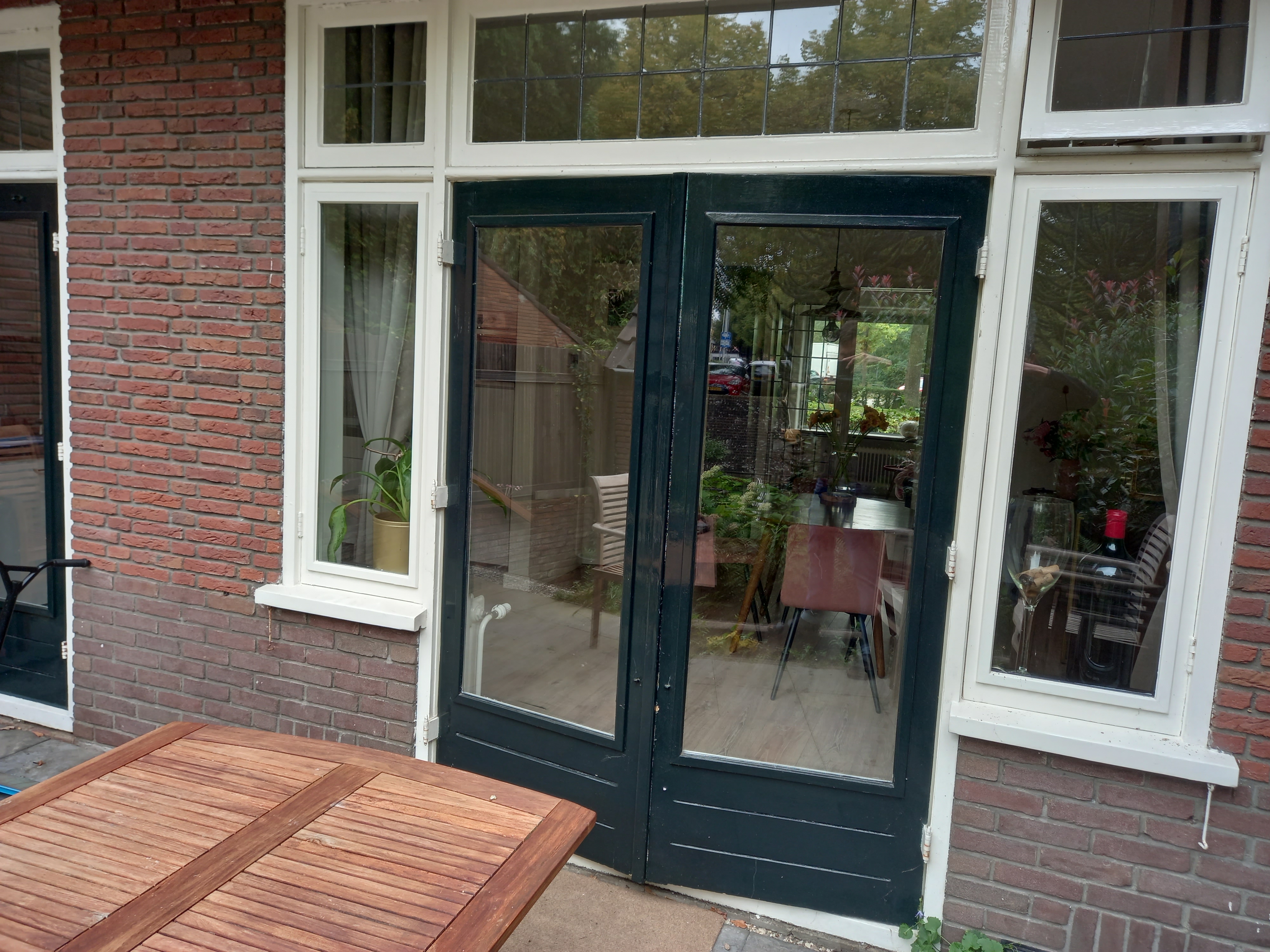 Foto van openslaande deuren met aan beide zijden smalle ramen.