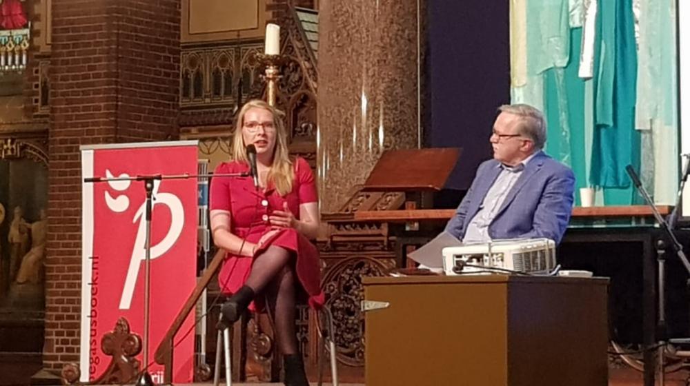 Charlotte van Rooden en Jan Willem Bos in gesprek op het podium.