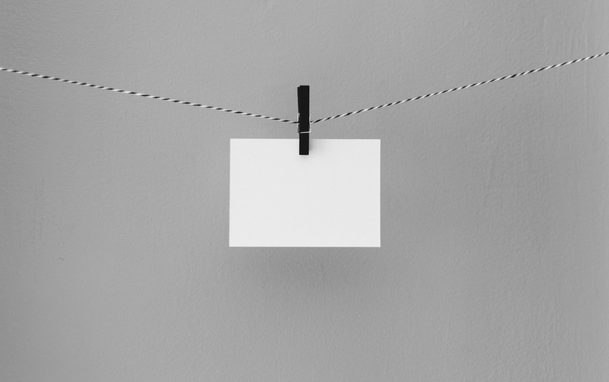 Decoratieve afbeelding van een velletje papier aan een waslijn.