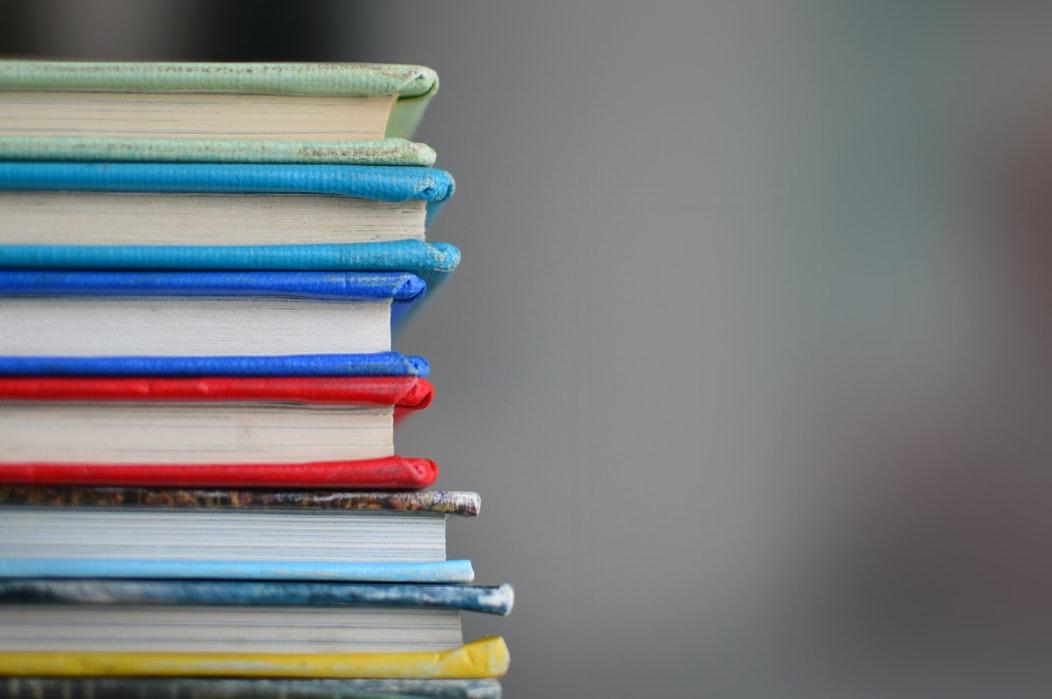 Decoratieve afbeelding van een stapel boeken met gekleurde kaften.