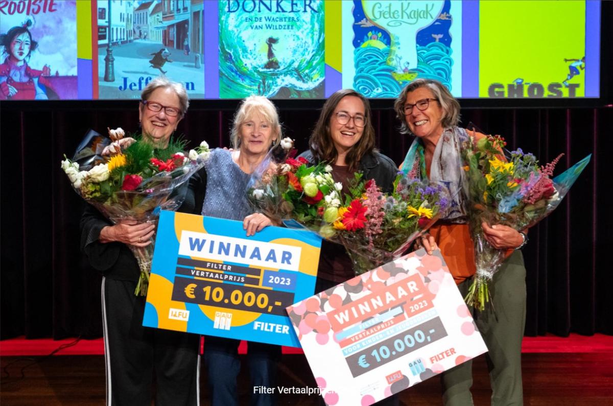 vier winnaars van de Filter Vertaalprijzen met cheques en bloemen